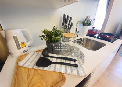 Modern kitchen with utensils, plants, and appliances