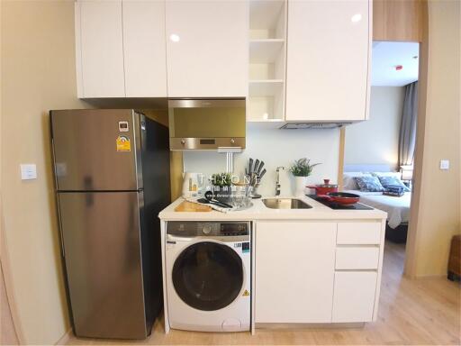 Modern kitchen with integrated stove and sink, fridge, and laundry machine