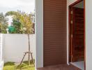 Exterior view of the house entrance with wooden door and small garden