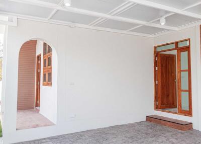 Covered entryway with wooden door and window