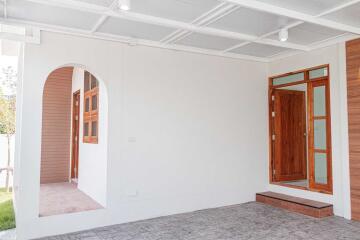 Covered entryway with wooden door and window