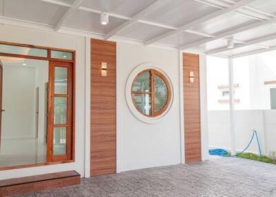 Modern house entrance with wooden accents and circular window