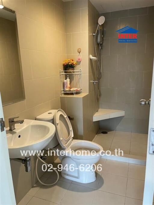 modern bathroom with tiling, sink, toilet, and shower area