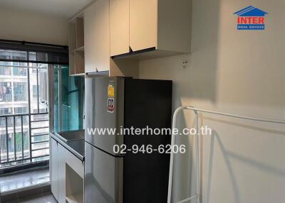 Modern kitchen with cabinets, refrigerator, and balcony access