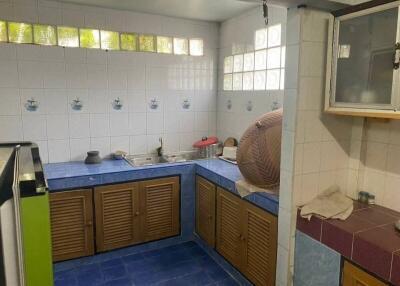 Corner kitchen with blue tiles and wooden cabinetry