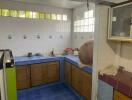 Corner kitchen with blue tiles and wooden cabinetry