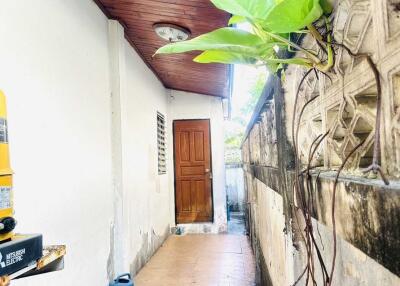 Outdoor hallway with wooden ceiling and door