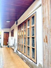 Exterior view of a building with a wooden door and large windows