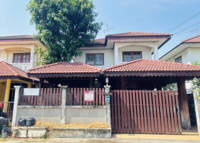 Exterior view of a residential house with gated entrance and tiled roof