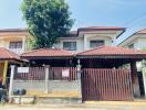 Exterior view of a residential house with gated entrance and tiled roof