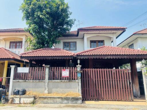 Exterior view of a residential house with gated entrance and tiled roof