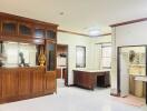 Main living space with wooden cabinets and desk, visible kitchen and bathroom