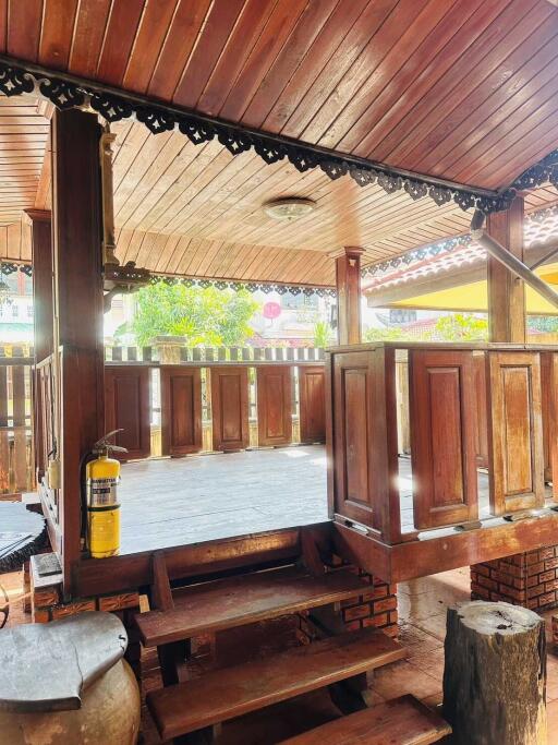 Wooden porch with ceiling decor and safety fire extinguisher