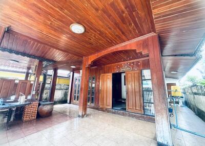 Covered patio area with wooden ceiling and pillars