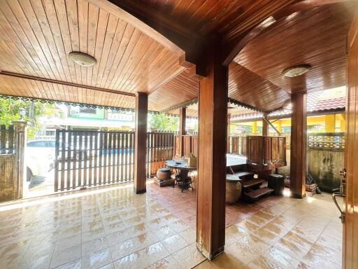 Covered outdoor patio area with wooden ceiling and tiled floor
