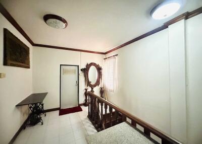 Well-lit staircase landing with wall-mounted decor and a large mirror