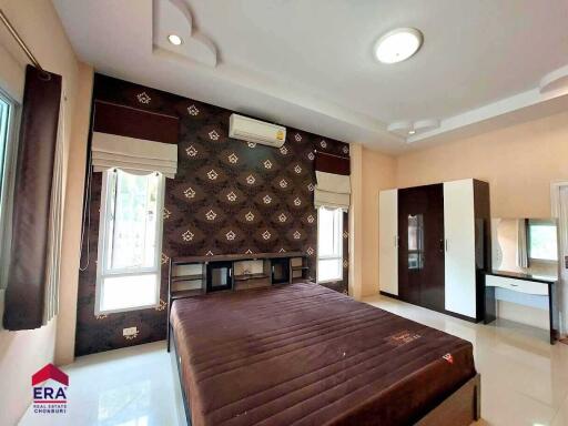 Spacious bedroom with large bed, stylish wall design, and modern furnishings