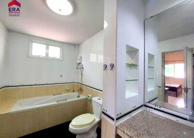Modern bathroom with large bathtub and separate toilet area