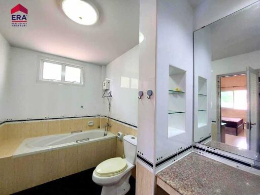 Modern bathroom with large bathtub and separate toilet area