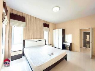 Spacious bedroom with a large bed, wardrobe, and dressing table