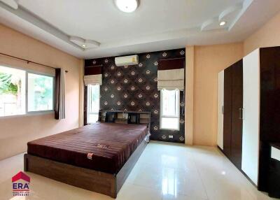 Modern furnished bedroom with large window and wardrobe