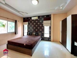 Modern furnished bedroom with large window and wardrobe