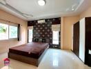 Modern furnished bedroom with large window and wardrobe