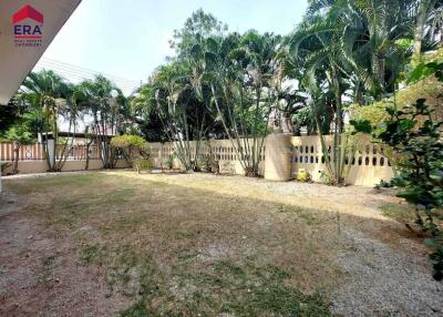 Spacious backyard with palm trees and grass area