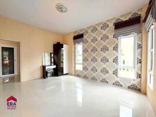 Spacious bedroom with large windows and patterned wallpaper