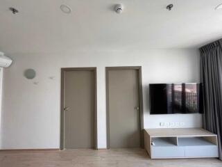 Living room with doors, TV, and AC unit