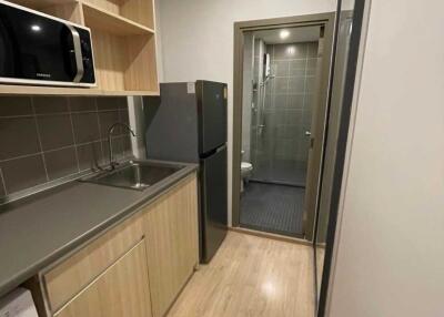 Modern compact kitchen with appliances and washer, adjacent to a bathroom