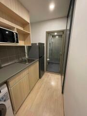 Modern compact kitchen with appliances and washer, adjacent to a bathroom