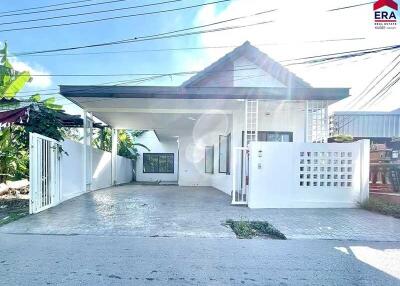 Front view of a modern white house with carport