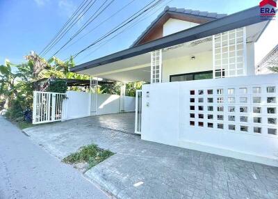 Front view of a modern house with a driveway and gate