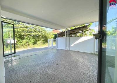 covered outdoor area with tiled floor and adjacent greenery