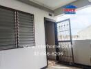 Outdoor hallway with a metal door and louvered window