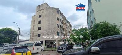 Exterior view of a residential building with multiple floors and parking lot