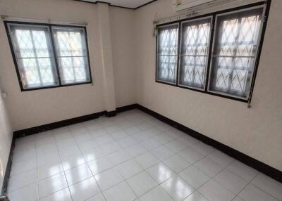 Empty bedroom with tiled floor and large windows