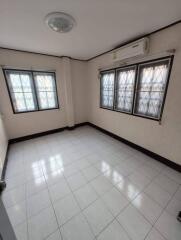 Empty bedroom with tiled floor and large windows