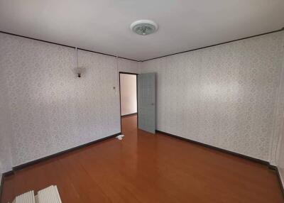 Spacious empty bedroom with light fixtures and wooden floor