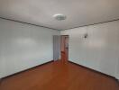 Empty bedroom with wooden floor and white walls