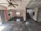 Spacious living room with tiled floor, ceiling fan, and large windows