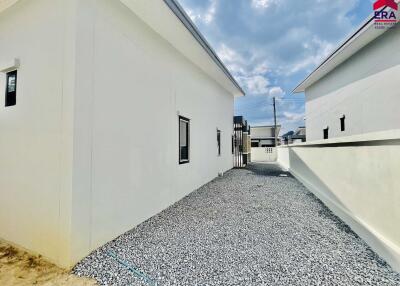 Modern white building exterior with gravel pathway