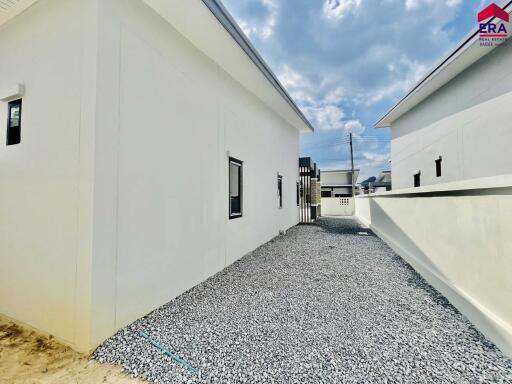 Modern white building exterior with gravel pathway