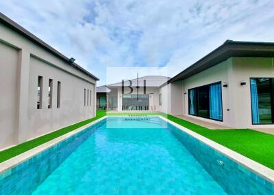 Modern house exterior with swimming pool and well-manicured lawn