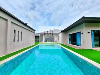 Modern house exterior with swimming pool and well-manicured lawn