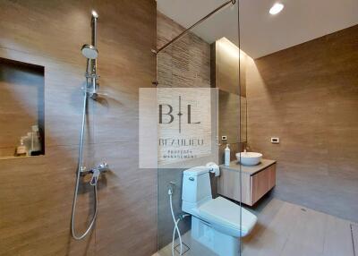 Modern bathroom with glass-enclosed shower and wooden accents