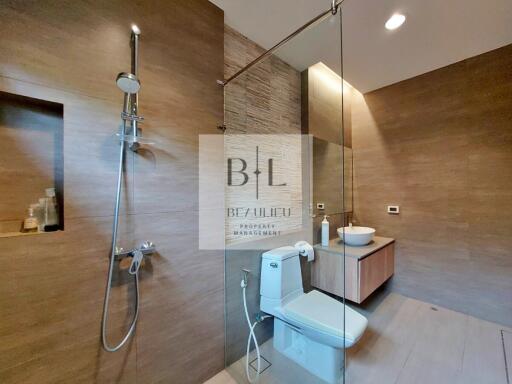 Modern bathroom with glass-enclosed shower and wooden accents