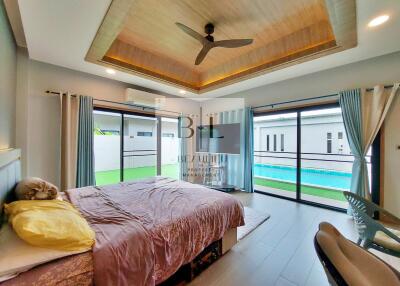 Modern bedroom with pool view and wooden ceiling