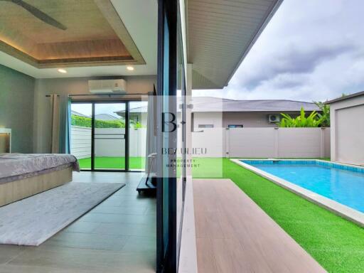 Bedroom with sliding glass door leading to a patio and swimming pool